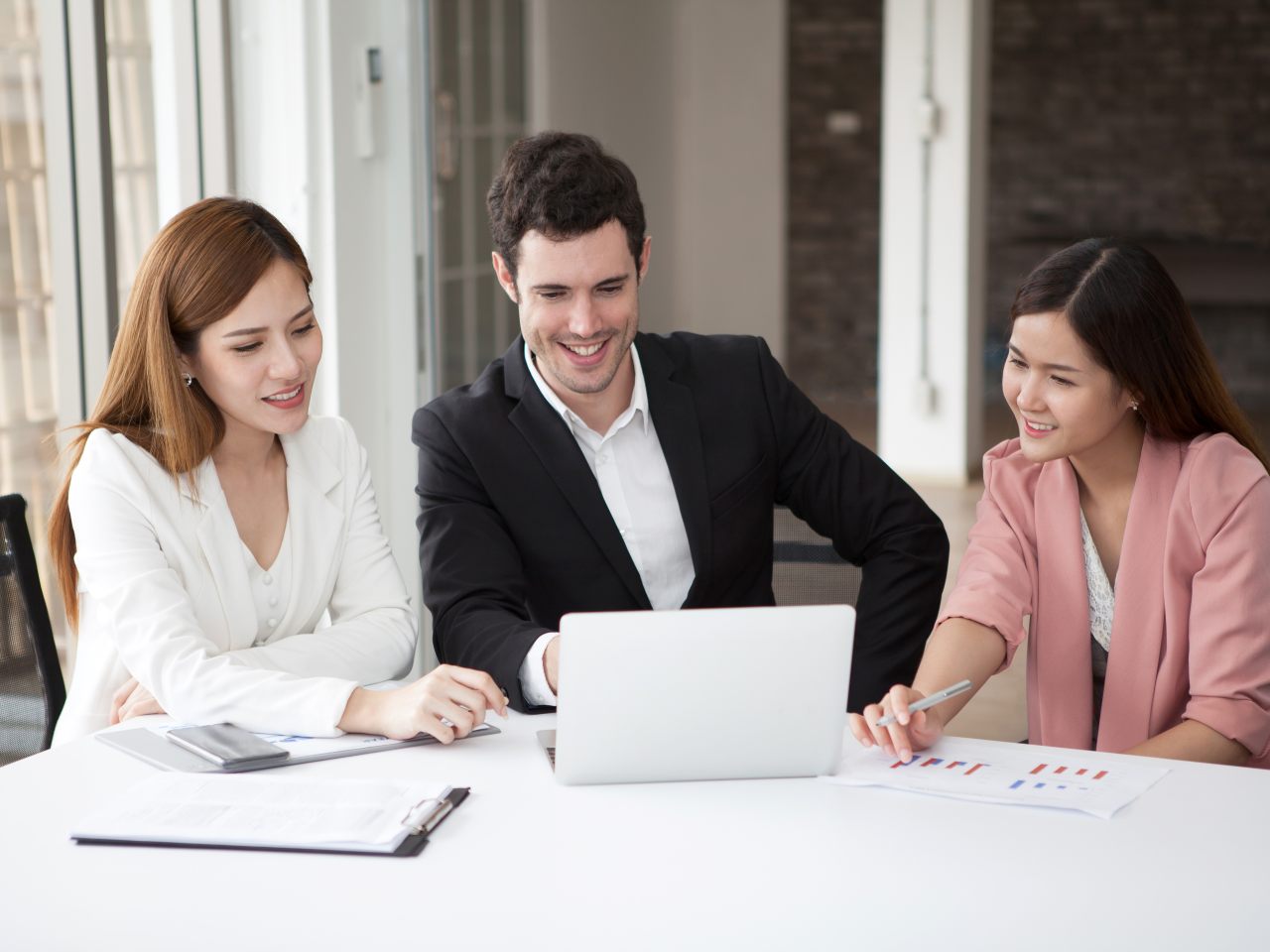 Technology projects explained (Business man and women working together on laptop in meeting room)